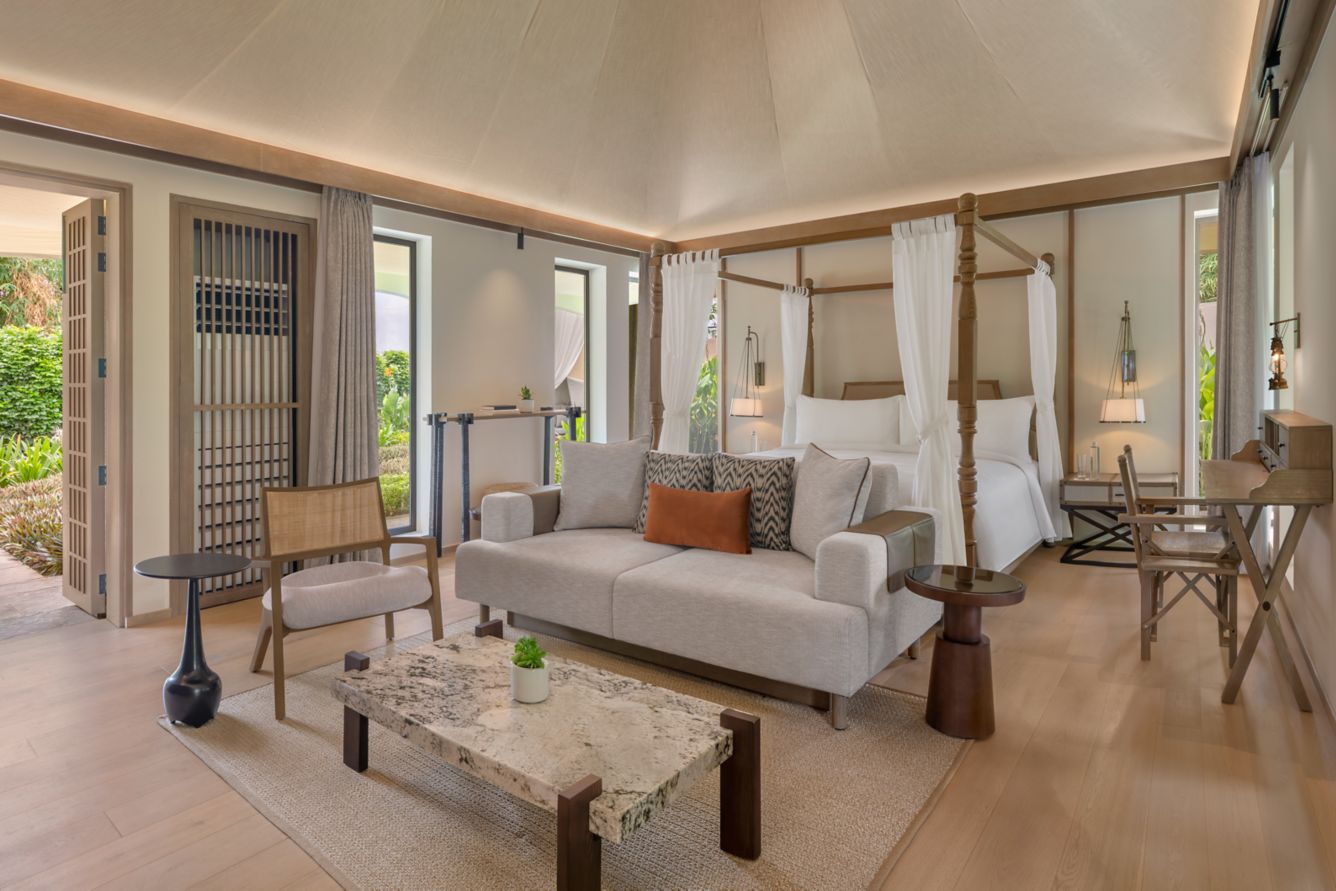 Tent suite interior with four-poster bed and lounge seating at JW Marriott Ranthambore