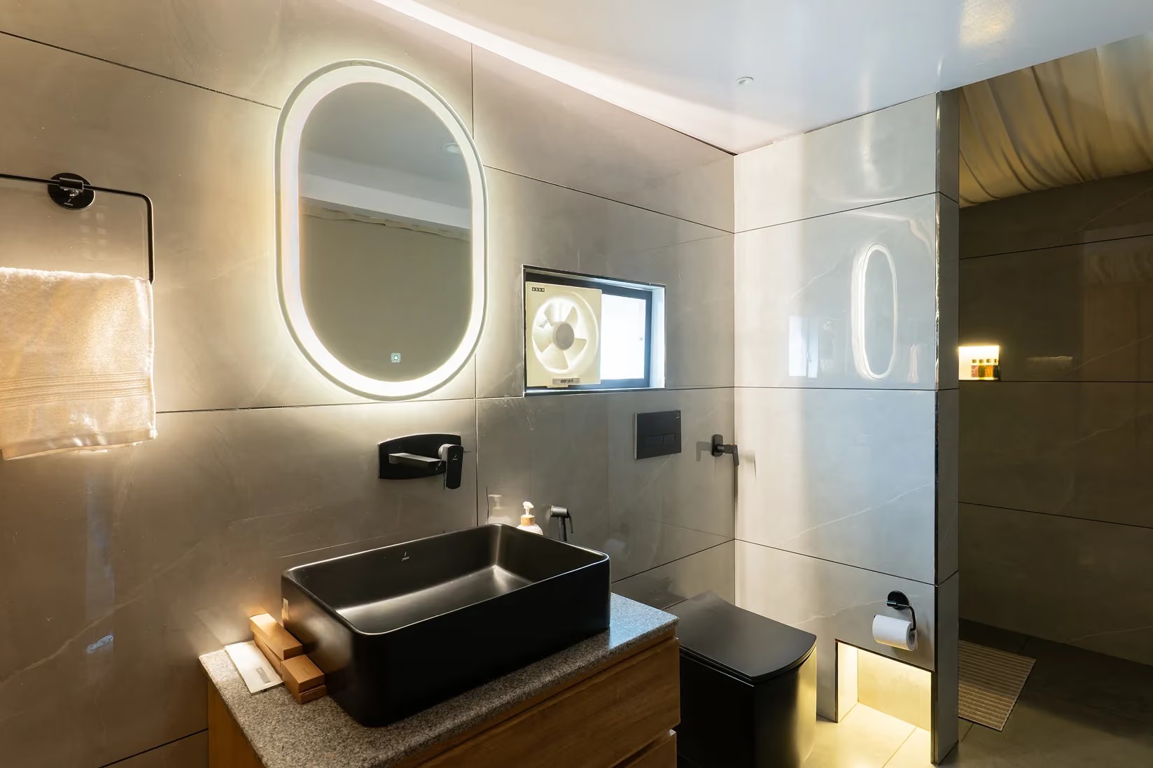 Tent bathroom with a black basin and illuminated mirror at Saraaya Glamps near Dharamshala